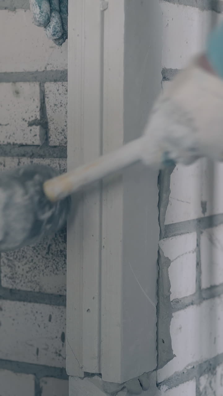 professional man hand fixes gypsum plasterboard lines on wall holding special rubber hammer close view