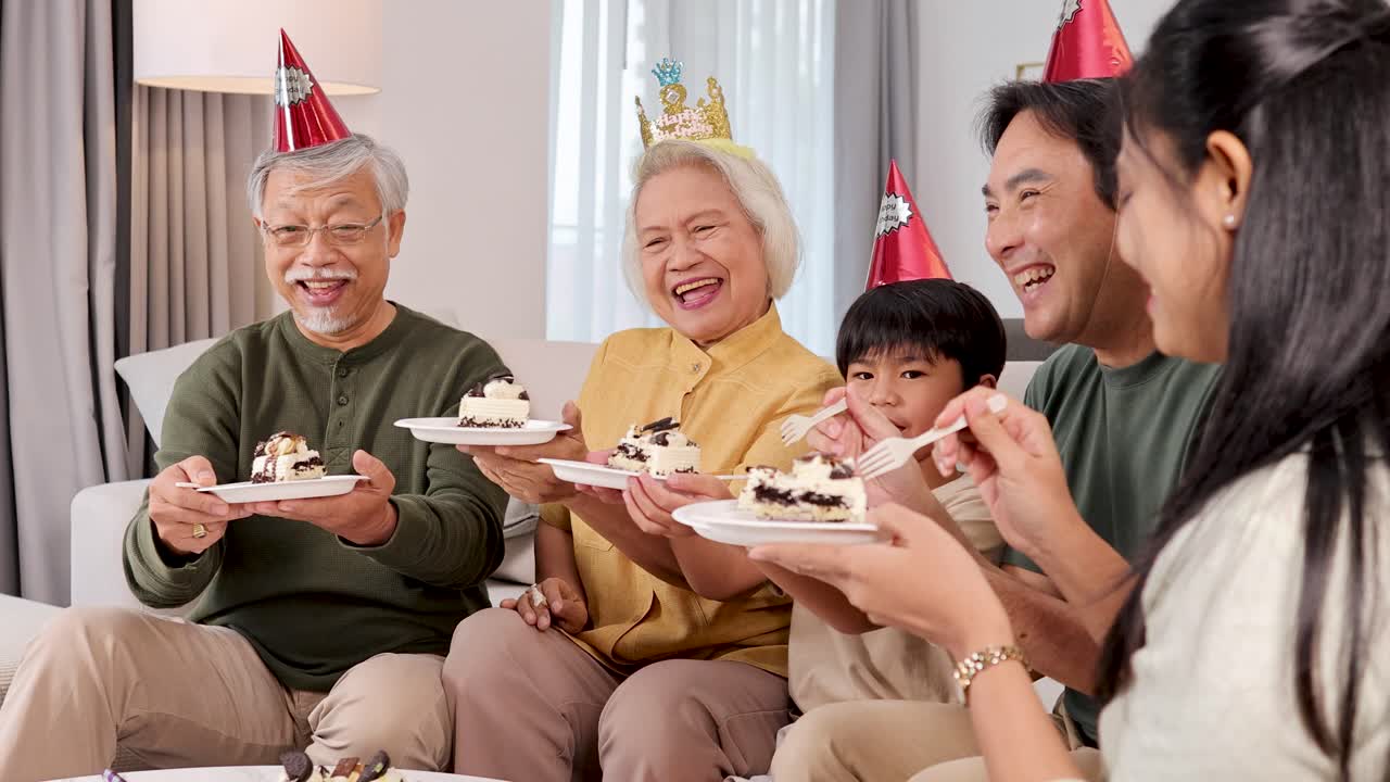 Family of three generations enjoys cake together in a festive, warmly lit setting, highlighting love and togetherness