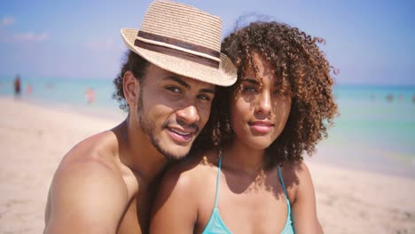 pareja mirando a la cámara en la playa