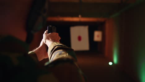 hombre con un arma disfrutando de disparos recreativos en interiores, de cerca