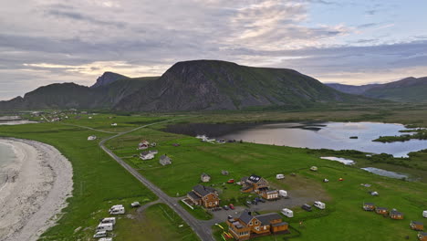 stave noruega aérea v1 vista impresionante, drone de bajo nivel sobrevuela el campamento junto al lago hacia un pequeño pueblo costero rodeado de un hermoso paisaje montañoso - filmado con mavic 3 cine - junio de 2022