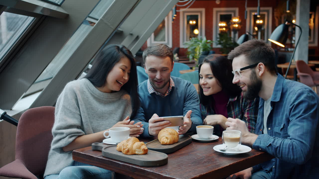 Friends Enjoying Coffee and Croissants in a Cafe