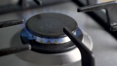 close-up slow motion shot of gas cooker stove top ignition turning on flame fire kitchen cooking hospitality food 4k