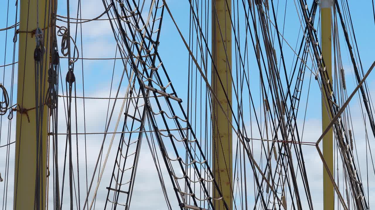 푹신한 구름이 있는 푸른 하늘을 배경으로 백라이트가 부드럽게 흔들리는 키 큰 선박 장비