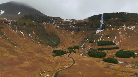 Atemberaubende-Aussicht-Auf-Die-Berge-Mit-Einem-Wasserfall,-Der-Von-Der-Spitze-Des-Berges-In-Island-Herabstürzt
