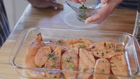 middle aged caucasian couple preparing meal, cooking together in kitchen at home, slow motion