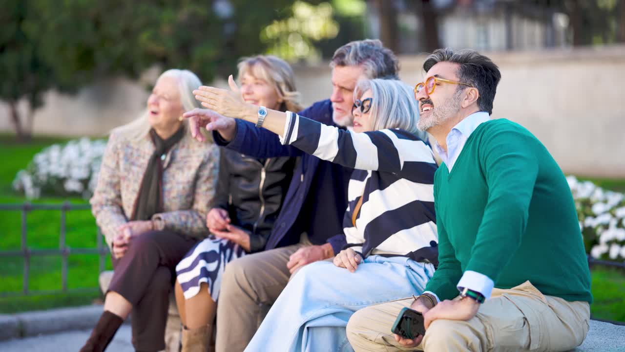 Group of happy mature people sitting together outdoors