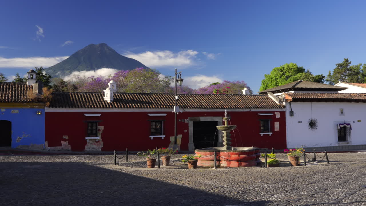 Etablering af pan over Antigua Guatemala med dramatisk vulkan og farverige koloni bygninger tidligt om morgenen