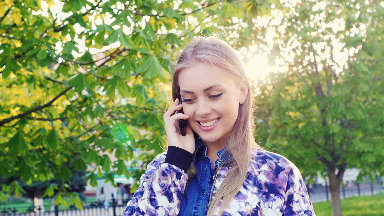 전화로 이야기하는 공원에서 산책하는 젊은 여성 prores hq 422 10 bit