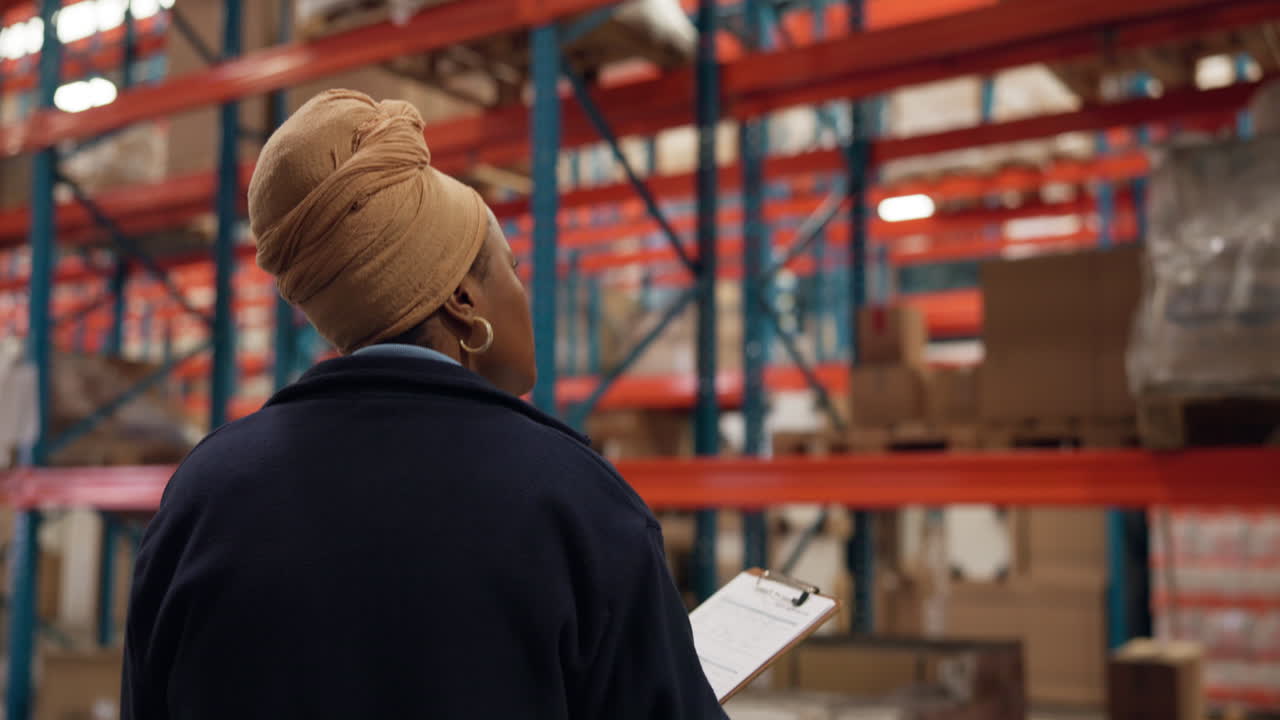 Woman with Clipboard Inspecting Inventory in a Large Warehouse