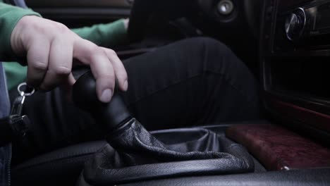 driver shifting gears of a car while driving close up