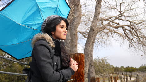 an attractive woman in a rain storm as the wind blows her umbrella inside out and she looks frustrated in bad weather slow motion