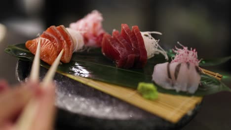 hand picking up sushi from a platter