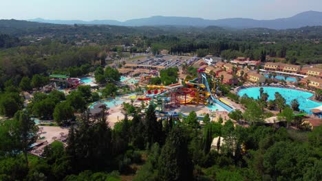 wide orbiting drone shot of a busy water park during a sunny summer day