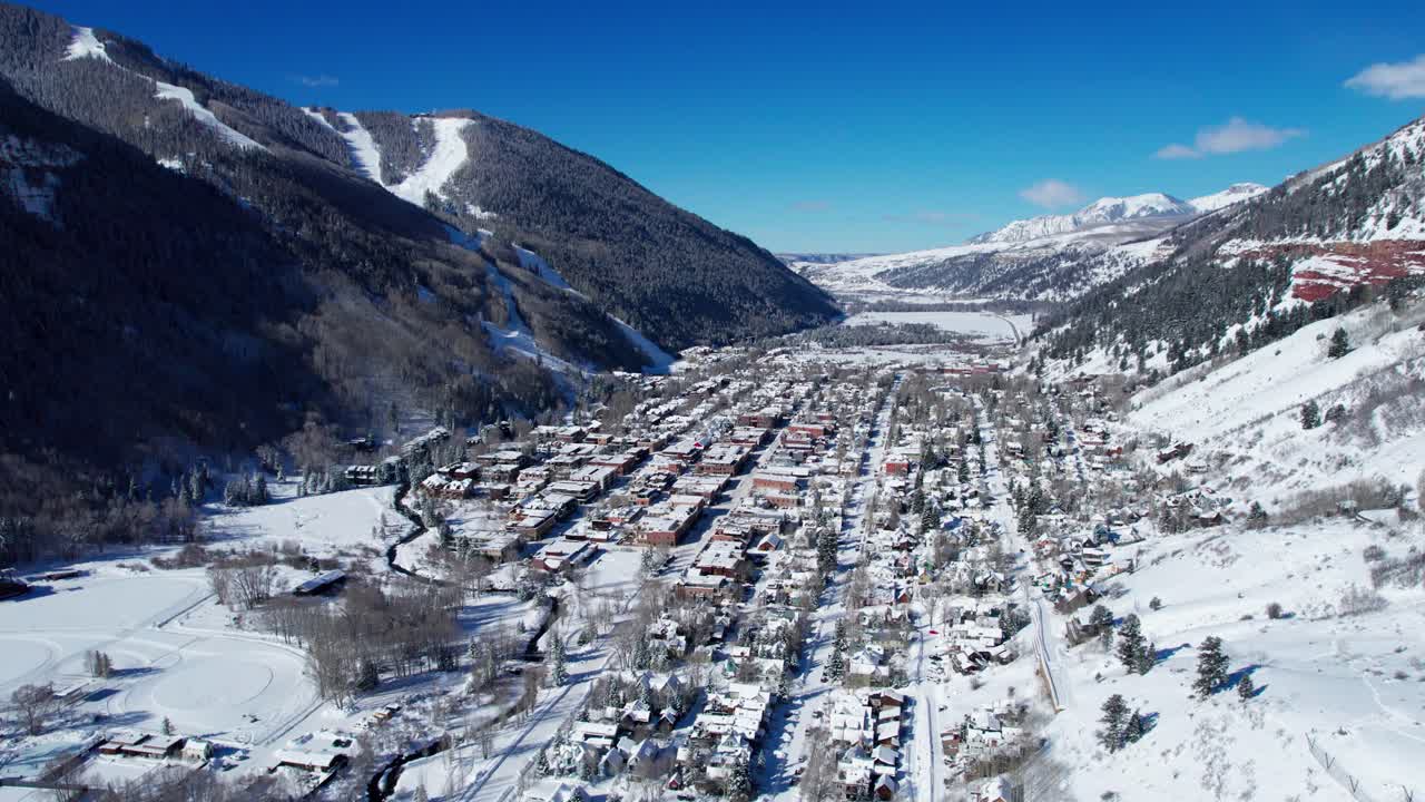 drone volando hacia teluride, colorado en un día claro y soleado en invierno