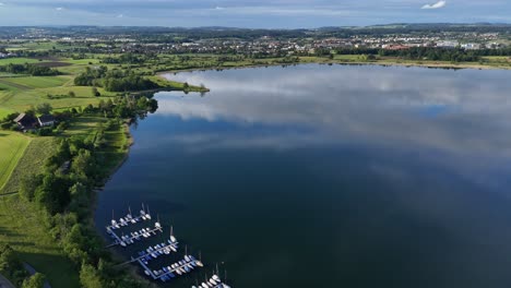 Malerische-Luftaufnahme-Von-Booten,-Die-Am-Greifensee-In-Der-Schweiz-Angedockt-Sind,-Mit-üppiger-Grüner-Landschaft