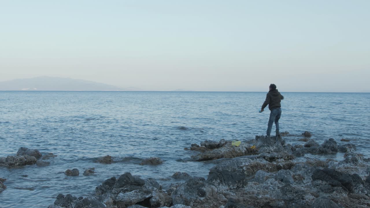 joven pescando sedal en el mar costa ancha