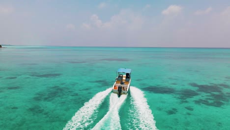el barco navega en la superficie del agua de color turquesa en las maldivas cerca de la isla, lo que requiere árboles verdes