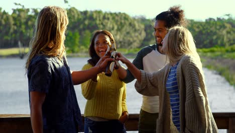 Happy-friends-toasting-beer-bottles-in-cabin-4k-