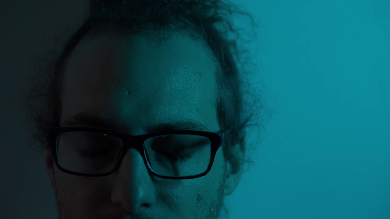 Close-up Portrait of a Man with Glasses in Neon Red and Blue Light