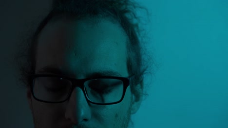 close-up portrait of a man with glasses in neon red and blue light
