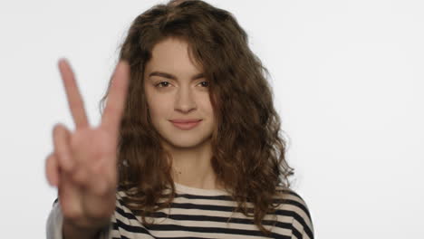 young woman showing v sign hand on white background. girl showing peace hand