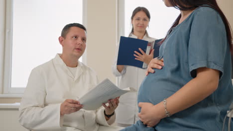 doctor discussing medical records with pregnant woman