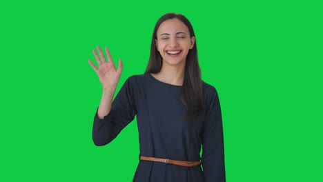 happy indian girl waving hi to the camera green screen