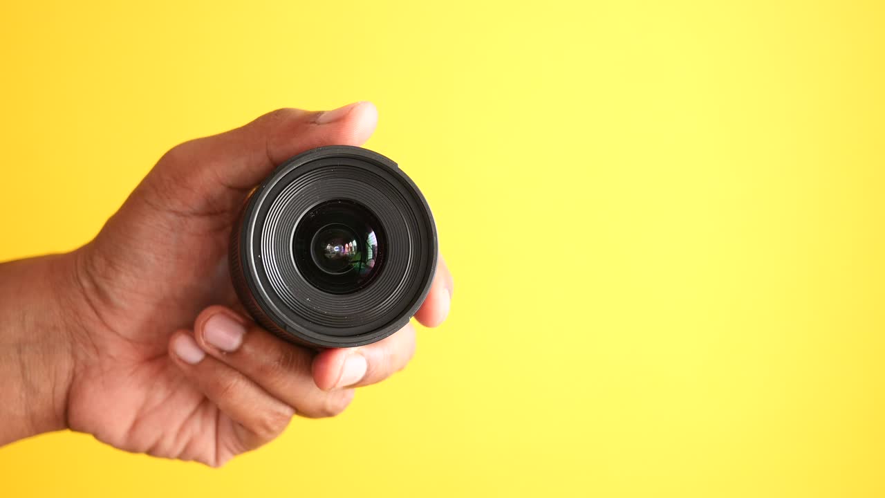 mano con una lente de cámara