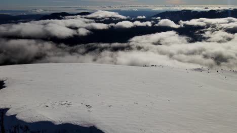 vistas aéreas de una cordillera en los pirineos españoles cubierta de nieve y con nubes en el horizonte