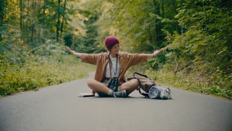 Carefree-Female-Tourist-Sitting-On-Footpath-In-Forest