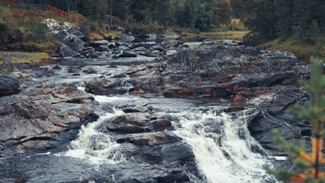 a mountain river surrounded by stark northern landscape cascades in the rocky riverbed
