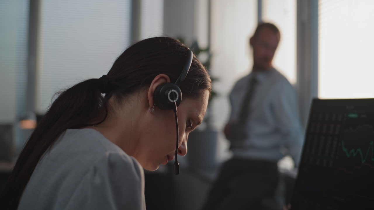 Woman working on a computer with headset