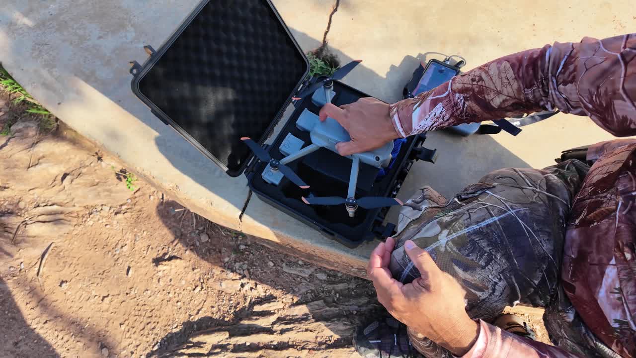 Man replaces drone battery outdoors for continued flight adventure