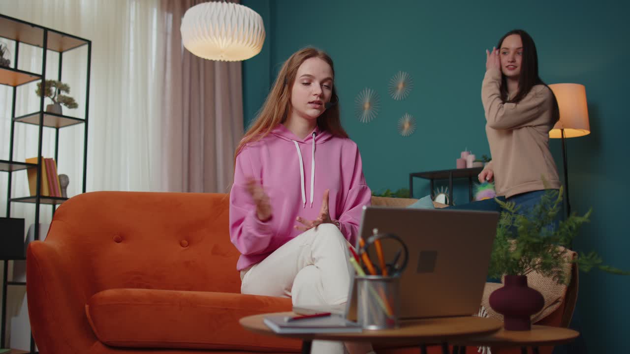 Woman freelance wear headphone make video call tutoring talking teaching looking at laptop at home