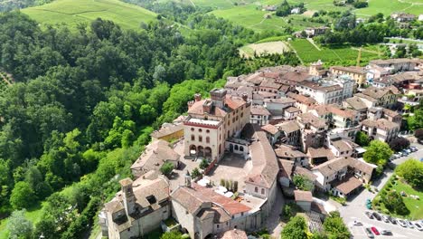 barolo castle in langhe wine region, cuneo, piedmont, italy. 4k aerial view of the village and the vineyards, flying backward ascending, revealing the town.