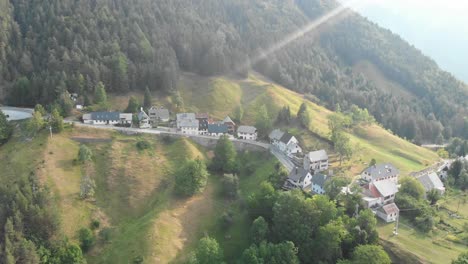 drone-flies-away-from-Strmec-village-in-julian-alps,-triglav-national-park