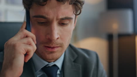 Mad man arguing mobile phone sitting office closeup. Businessman feeling angry