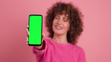 happy woman showing mobile phone with chromakey in studio