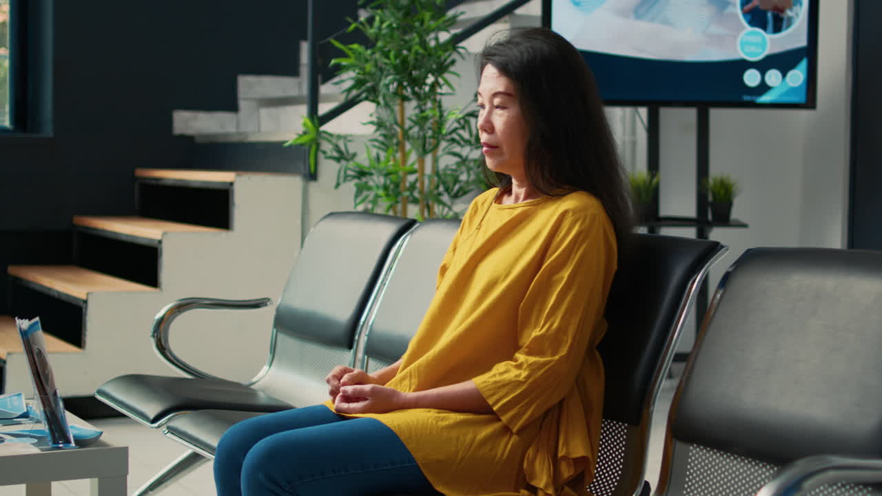 Asian woman waiting in hospital lobby