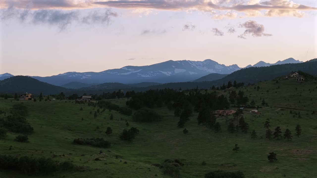 Drone footage of a summer sunset over the mountains near Boulder, Colorado. Aerial view of scenic wilderness, ridges, and forested landscapes.