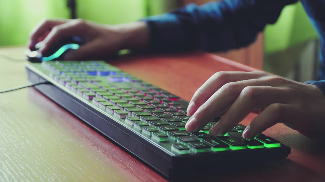 joven jugador juega un videojuego utiliza el teclado iluminado del juego 01