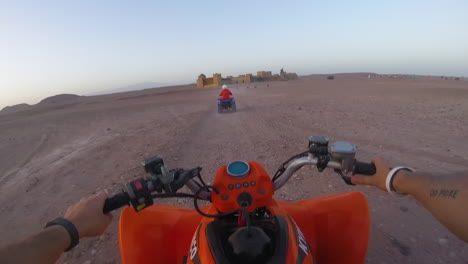 tourists relishing the thrill of quad biking in marrakesh, morocco - pov