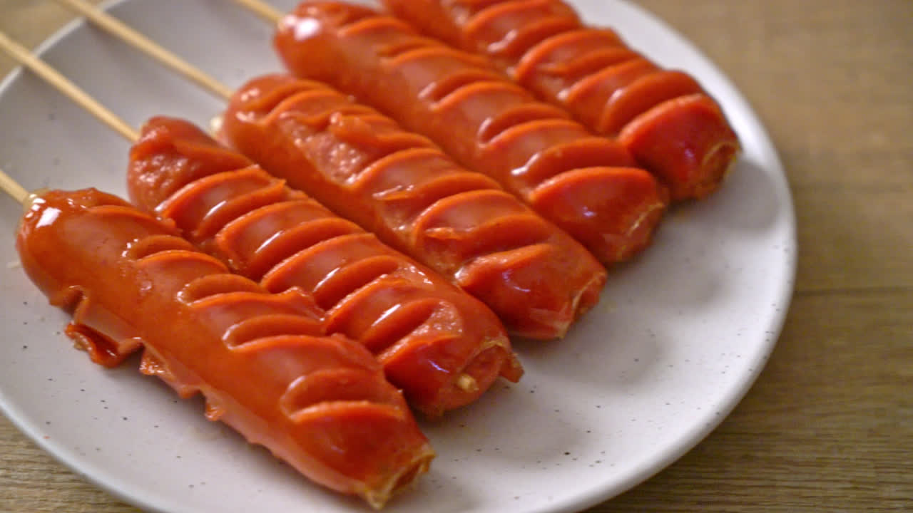 흰색 접시에 튀긴 된 소시지 꼬치