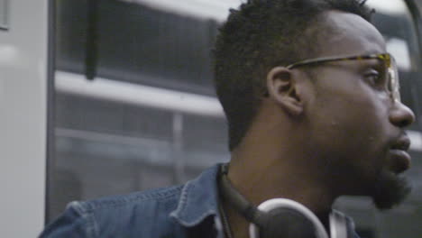 hombre afroamericano con gafas llegando a su parada en un metro