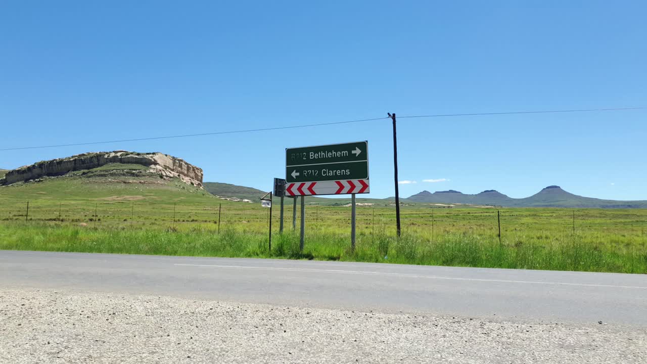 R712 road outside Clarens town in Free-state province South Africa with cars and motorbike traffic traveling past on vacation in Moluti Mountains.