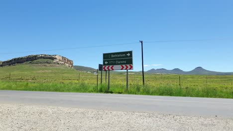 r712 road outside clarens town in free-state province south africa with cars and motorbike traffic traveling past on vacation in moluti mountains.