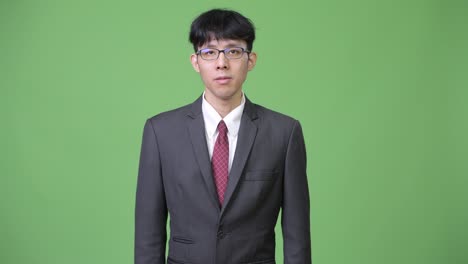 young asian businessman against green background