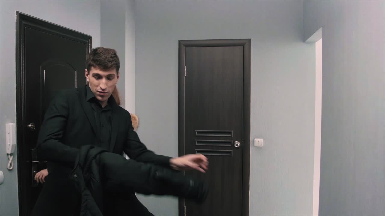 Man in a Black Suit in a Hallway