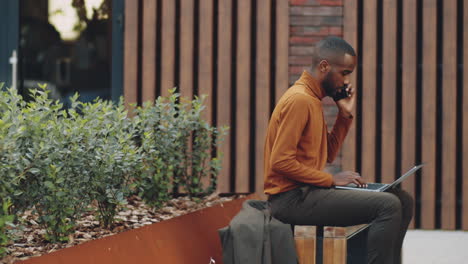 time lapse of african american businessman working on street bench